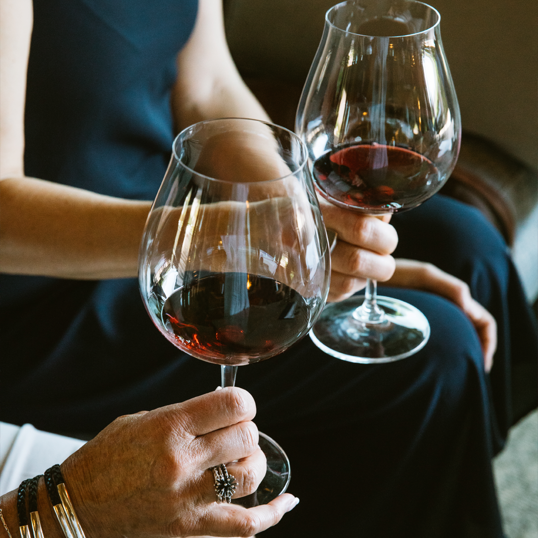 Guests holding glasses of red wine