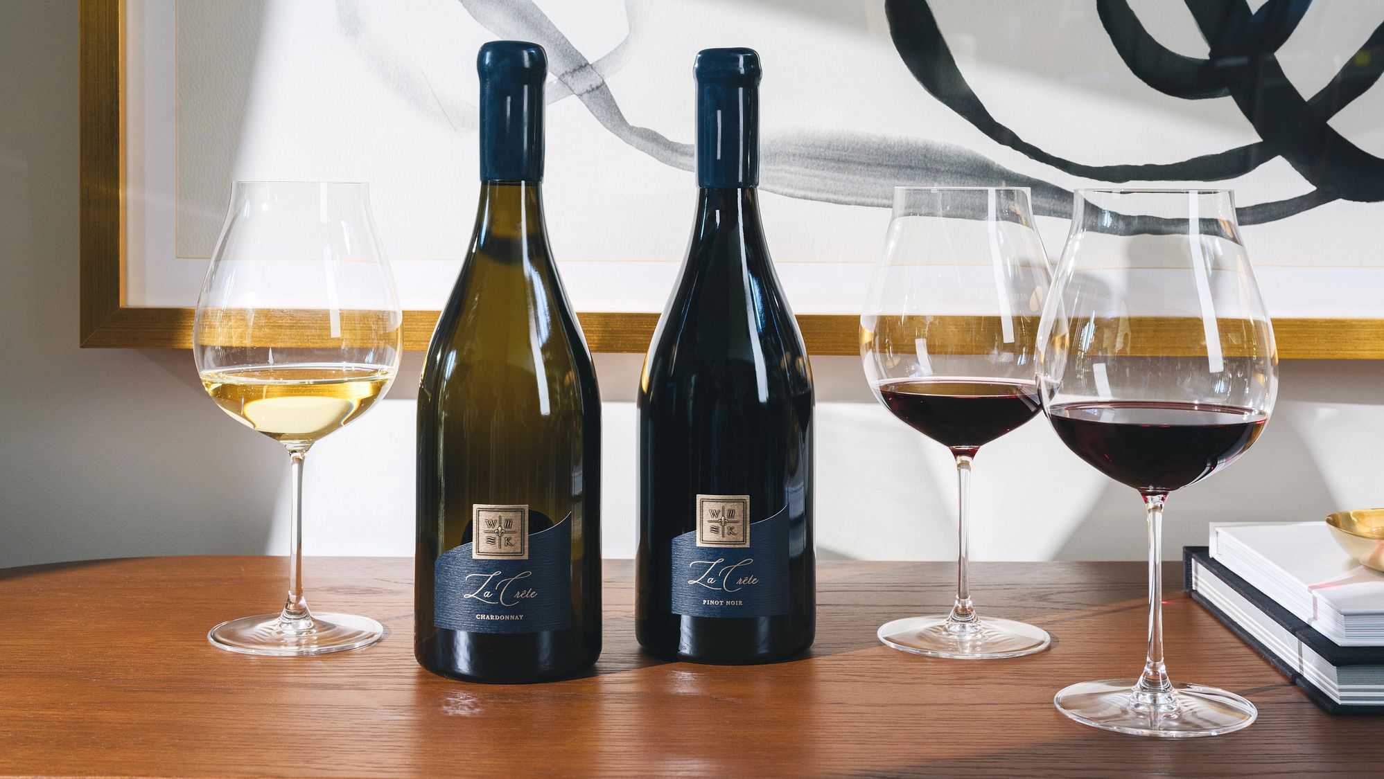 la crete chardonnay and pinot noir bottles with a glass of wine