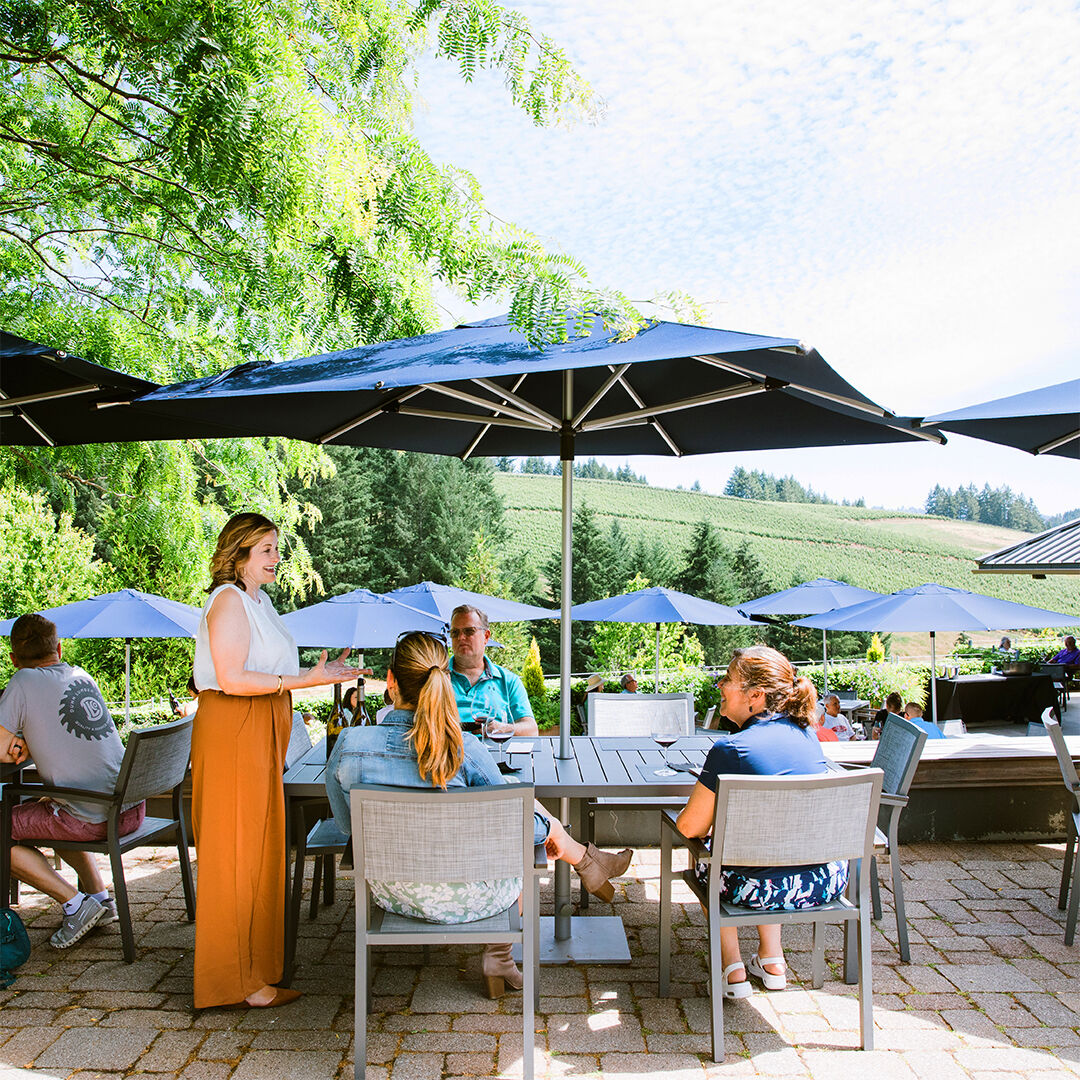 3 women holding wine glasses outside WillaKenzie Estate tasting room
